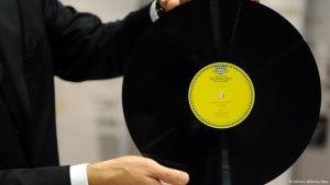 Primer LP de vinilo presentado por Deutsche Grammophon en 1951, sostenido por una persona durante una exhibición