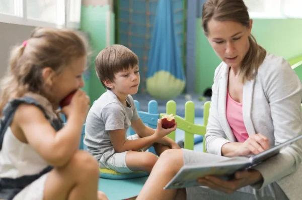Educadora infantil leyendo un cuento a niños en un aula de guardería