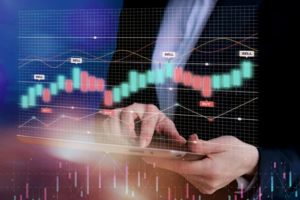 Persona utilizando una tablet con gráficos de velas de trading superpuestos, mostrando señales de compra y venta en un entorno financiero digital.