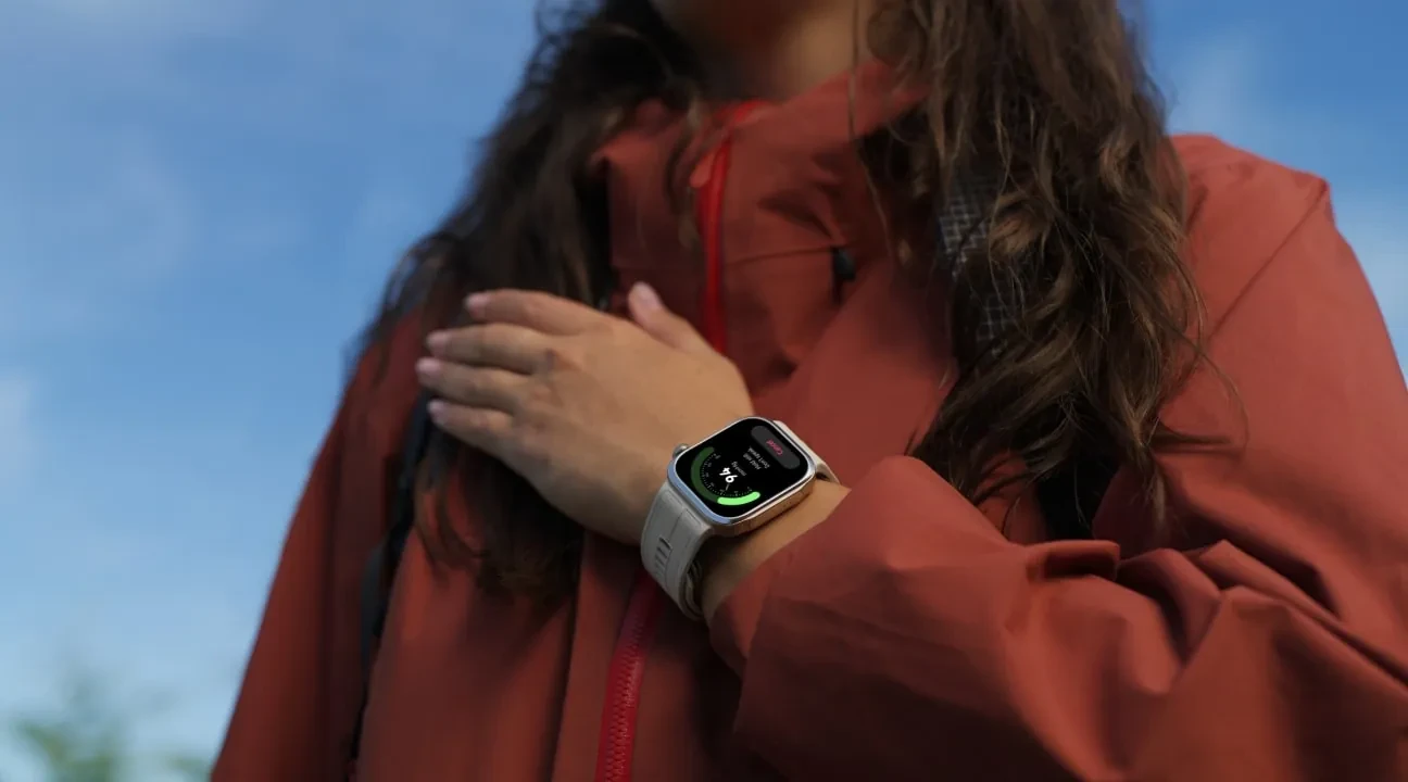 mujer con con mano en pecho y reloj en muñeca
